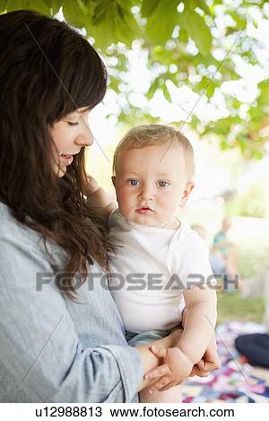 Stock Image - Young mother embracing baby boy (6-11 months) . Fotosearch