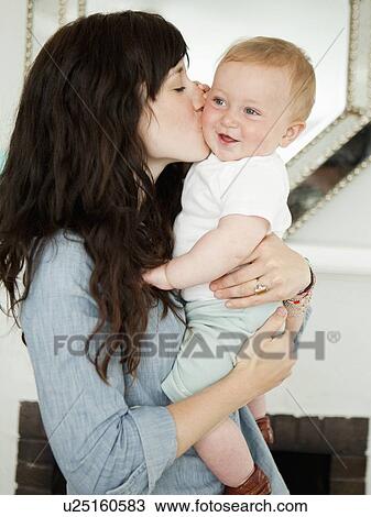Stock Image - Young mother embracing baby boy (6-11 months) . Fotosearch
