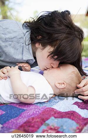 Young mother kissing baby boy (6-11 months) View Large Photo Image Stock Photo - Young mother kissing baby boy (6-11 months) . Fotosearch