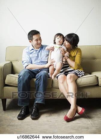 Picture - Young parents with baby girl (12-17 months). Fotosearch