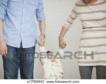Stock Image - Young parents with baby girl (12-17 months). Fotosearch