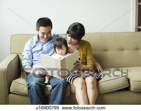 Young parents with baby girl (12-17 months) reading book View Large Photo Image Stock Photography - Young parents with baby girl (12-17 months) reading book. Fotosearch