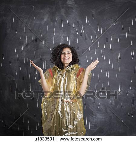 Young teacher wearing raincoat posing against blackboard with V marks imitating rain View Large Photo Image Stock Image - Young teacher wearing raincoat posing against blackboard with V marks imitating rain. Fotosearch