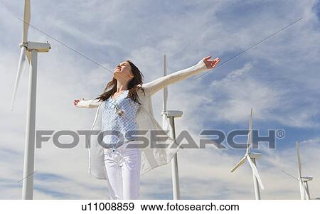 Stock Photo - Young woman at wind farm. Fotosearch