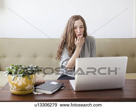 Young woman blowing kiss while using laptop View Large Photo Image Stock Photo - Young woman blowing kiss while using laptop. Fotosearch