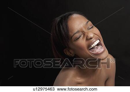 Stock Image - Young woman bursting with laugh. Fotosearch