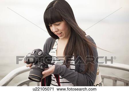 Young woman checking photos in camera View Large Photo Image Stock Image - Young woman checking photos in camera. Fotosearch