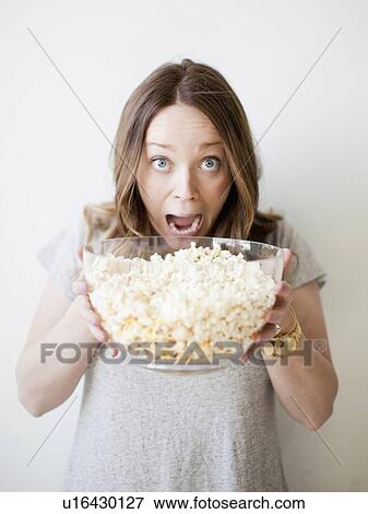 Young woman devouring bowl of popcorn View Large Photo Image Stock Photo - Young woman devouring bowl of popcorn. Fotosearch