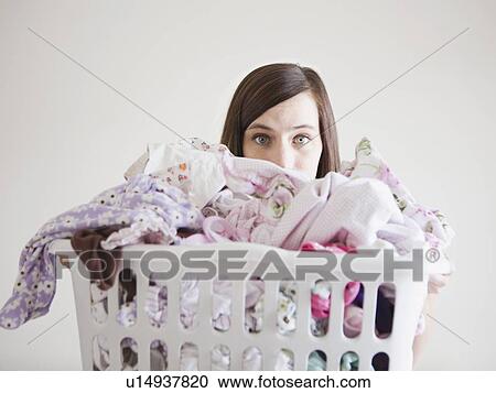 Stock Image - Young woman doing laundry. Fotosearch