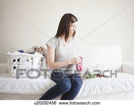 Young woman doing laundry View Large Photo Image Stock Photograph - Young woman doing laundry. Fotosearch