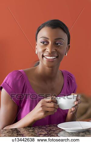 Young woman enjoying morning coffee View Large Photo Image Stock Photo - Young woman enjoying morning coffee. Fotosearch