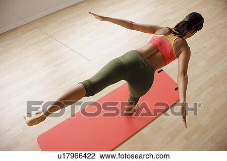 Stock Image - Young woman exercising. Fotosearch