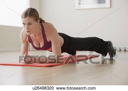 Stock Image - Young woman exercising. Fotosearch