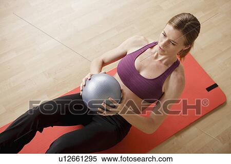 Stock Photography - Young woman exercising. Fotosearch