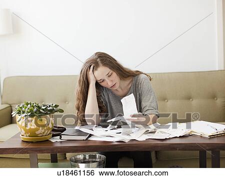 Young woman going though domestic paperwork View Large Photo Image Stock Photograph - Young woman going though domestic paperwork. Fotosearch