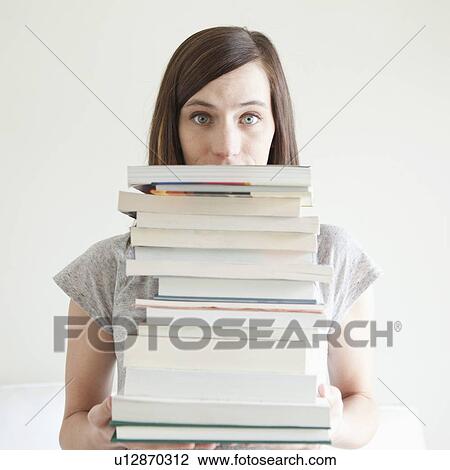Young woman holding stack of books View Large Photo Image Stock Image - Young woman holding stack of books. Fotosearch