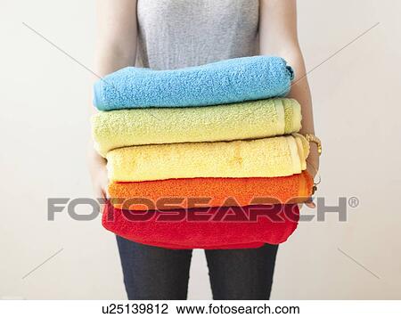 Young woman holding stack of towels View Large Photo Image Stock Image - Young woman holding stack of towels. Fotosearch