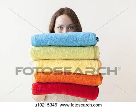 Young woman holding stack of towels View Large Photo Image Stock Photograph - Young woman holding stack of towels. Fotosearch