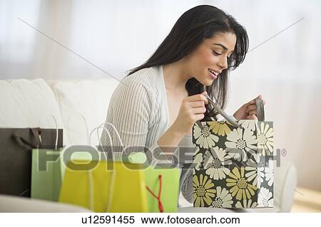 Young woman looking into shopping bag View Large Photo Image Stock Photography - Young woman looking into shopping bag. Fotosearch