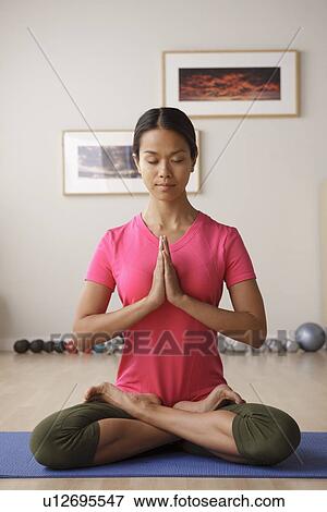 Stock Photo - Young woman meditating. Fotosearch