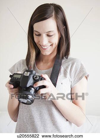 Young woman playing with digital camera View Large Photo Image Stock Image - Young woman playing with digital camera. Fotosearch