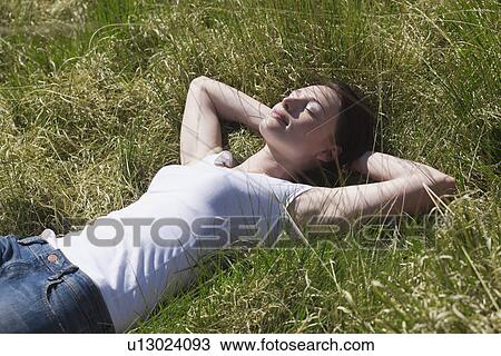 Young woman relaxing on meadow View Large Photo Image Stock Image - Young woman relaxing on meadow. Fotosearch