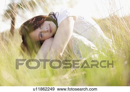 Stock Photo - Young woman relaxing on meadow. Fotosearch