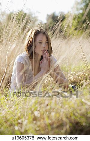 Stock Photo - Young woman relaxing on meadow. Fotosearch