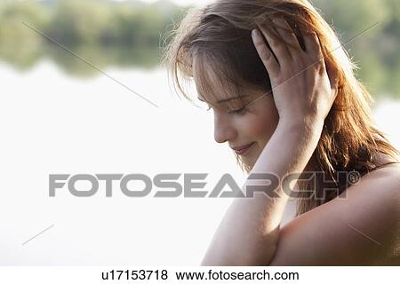 Young woman running head through hair View Large Photo Image Stock Photo - Young woman running head through hair. Fotosearch