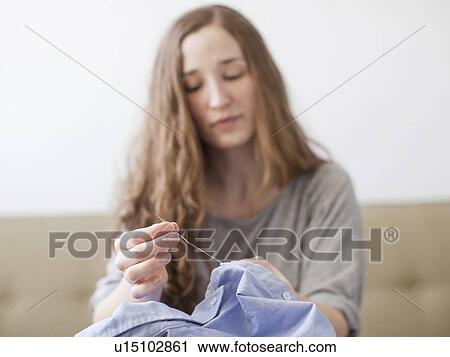Stock Image - Young woman sawing. Fotosearch
