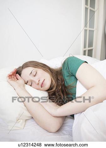Young woman sleeping in bed View Large Photo Image Stock Photo - Young woman sleeping in bed. Fotosearch