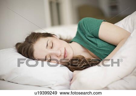 Young woman sleeping in bed View Large Photo Image Stock Photo - Young woman sleeping in bed. Fotosearch