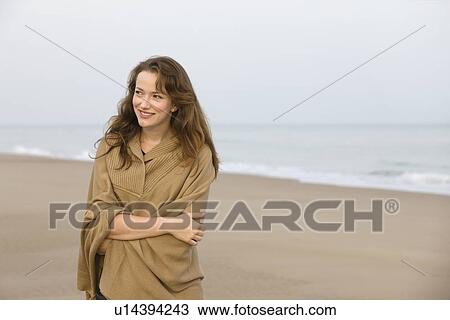 Young woman strolling on empty beach View Large Photo Image Stock Image - Young woman strolling on empty beach. Fotosearch