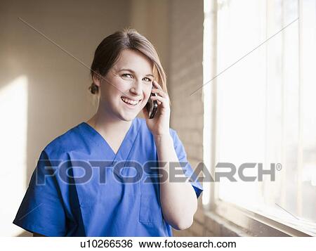 Stock Photograph - Young woman using mobile phone. Fotosearch