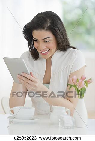 Young woman using tablet pc in restaurant View Large Photo Image Stock Image - Young woman using tablet pc in restaurant. Fotosearch
