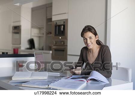 Picture - Young woman working from home. Fotosearch
