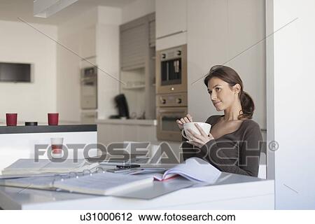 Stock Image - Young woman working from home. Fotosearch