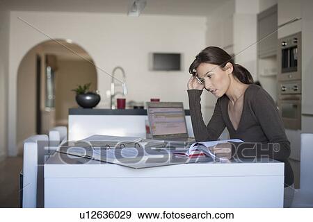 Stock Photo - Young woman working from home. Fotosearch