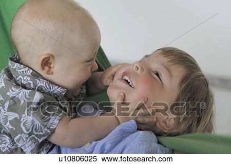 Baby boy and brother playing on couch View Large Photo Image Stock Photography - Baby boy and brother playing on couch. Fotosearch
