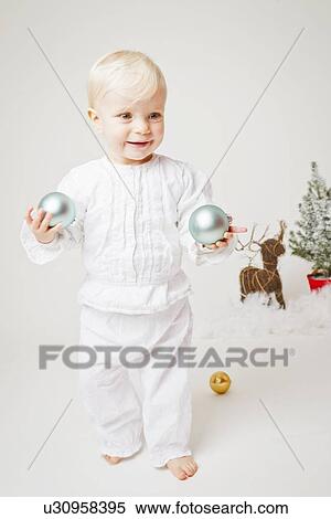 Baby girl holding Christmas ornaments View Large Photo Image Stock Photography - Baby girl holding Christmas ornaments. Fotosearch
