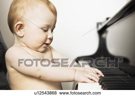 Stock Photo - Baby girl playing piano. Fotosearch