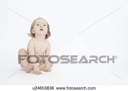 Stock Photo - Baby girl sitting on floor. Fotosearch