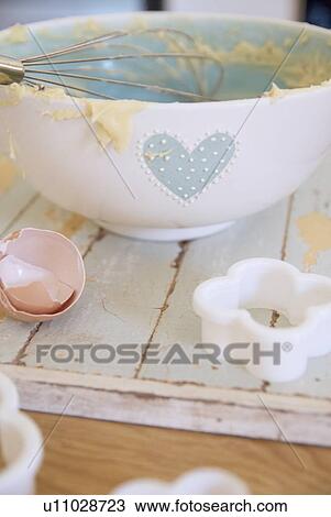 Stock Image - Bowl, egg and cookie cutter in kitchen. Fotosearch