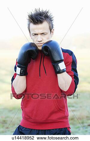 Boxer holding up gloves outdoors View Large Photo Image Stock Image - Boxer holding up gloves outdoors. Fotosearch
