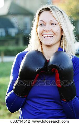Stock Image - Boxer holding up gloves outdoors. Fotosearch