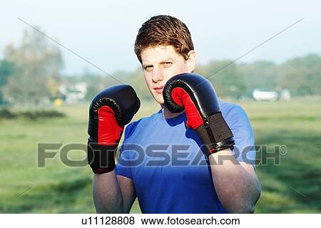 Boxer holding up gloves outdoors View Large Photo Image Stock Photo - Boxer holding up gloves outdoors. Fotosearch