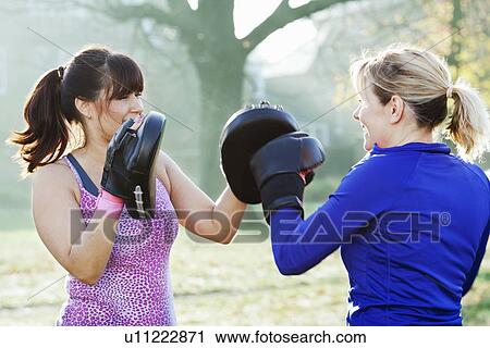 Stock Image - Boxer training with coach outdoors. Fotosearch