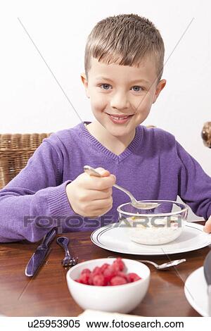 Stock Photography - Boy eating breakfast at table. Fotosearch