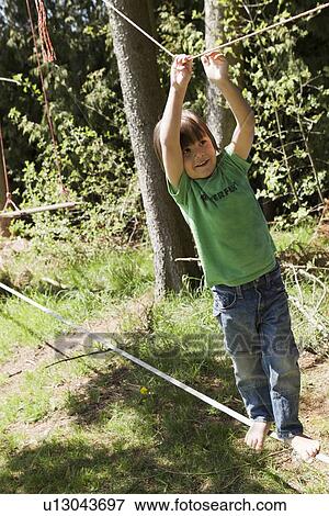 Boy playing on tightrope outdoors View Large Photo Image Stock Photo - Boy playing on tightrope outdoors. Fotosearch