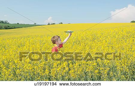 Boy playing with paper airplane in field View Large Photo Image Picture - Boy playing with paper airplane in field. Fotosearch